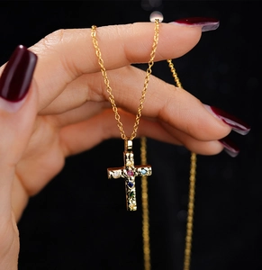 Macro shot of s925 silver gold cross pendant with colorful zircon stones and fine chain