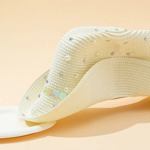 Close-up of straw sun hat with pearls, silver rhinestones and sequins on brim