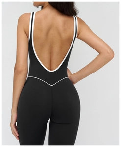 U-shaped open back detail of black yoga jumpsuit with white contrast piping
