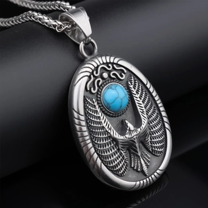 Detail of vintage eagle pendant with blue stone and relief patterns on a black stand