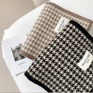 Close-up of knit houndstooth scarves in brown and black with premium wool texture