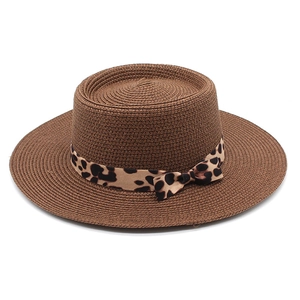 Detail of hand-woven straw hat crown with leopard print ribbon and side bow accent