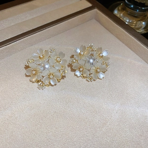Macro shot of pearl flower stud earrings with gold plating and sparkling crystals