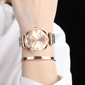 Detail of bicolour metal watch with rose gold sunray dial and matching love bracelet