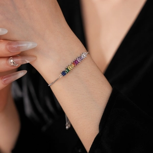 Detail of adjustable rainbow zircon bracelet with rectangular colored stones on wrist
