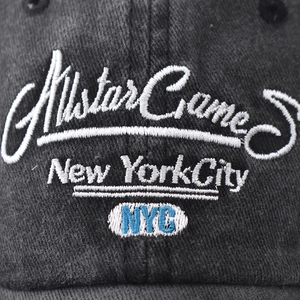 Macro detail of high-quality NYC embroidery on a black washed cotton baseball cap
