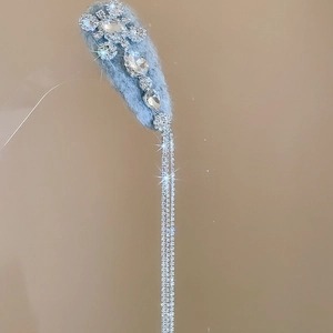 Close-up of light blue velvet drop hair clip with crystal snowflake and silver tassels