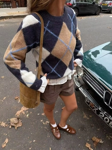 Detailed close-up of navy diamond argyle knit sweater with vintage plaid texture