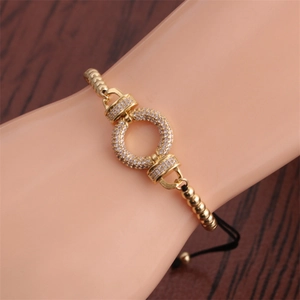 Detail of adjustable gold bracelet with colorful pavé rhinestones on dark wood background