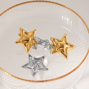 Polished stainless steel double star stud earrings in gold and silver set on glass
