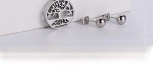 Detailed view of silver tree of life pendant set with polished ball stud earrings