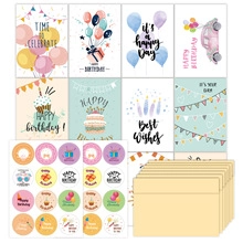 Flat lay of birthday greeting cards with round stickers and kraft paper envelopes