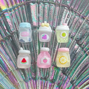 Flat lay of miniature resin juice bottles with fruit patterns on holographic background