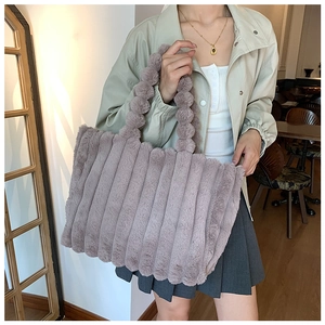 Detailed texture of dusty pink plush striped tote bag shown in lifestyle setting