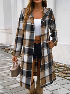 Outdoor portrait of long hooded plaid jacket in black, white, and brown wool blend fabric