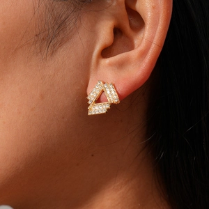 Close-up of elegant gold hollow geometric triangle earrings with sparkling crystals