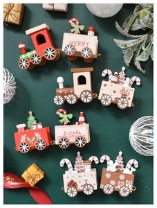 Top view of wooden Christmas train toys with gift boxes on dark green background
