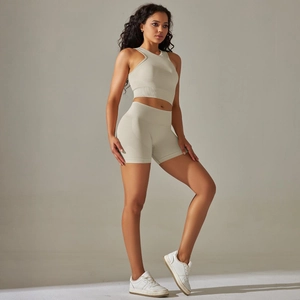 Detail of ribbed seamless yoga set showing light beige high-waist shorts and crop top