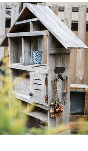 Detail van vintage houten tuinplank met verschillende vakken en metalen haken