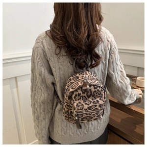 Gros plan d'un mini sac à dos vintage à imprimé léopard avec double zip et poignée supérieure