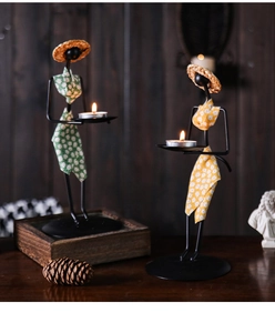 Détail de bougeoirs exotiques en fer avec tissu floral et petits chapeaux de paille