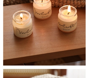 Close-up of three 20ml mini scented glass candles burning on a warm wooden table