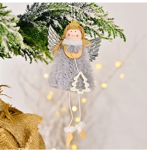 Detail eines Plüsch-Weihnachtsengels mit silbernen Flügeln an einem verschneiten Zweig