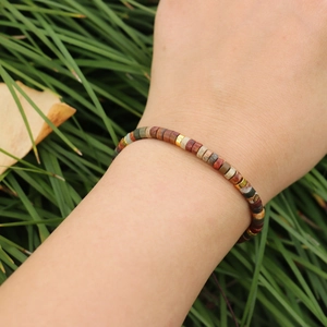 Close-up of imperial stone woven bracelet with golden spacer beads on model's wrist