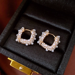 Détail des boucles d'oreilles en U plaquées or 18 carats avec perles et micro-cristaux