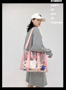 Detail of transparent PVC shoulder bag with pink strap and matching interior pouch