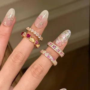 Chic vintage style gold ring set with pink diamonds and red heart gems on hand