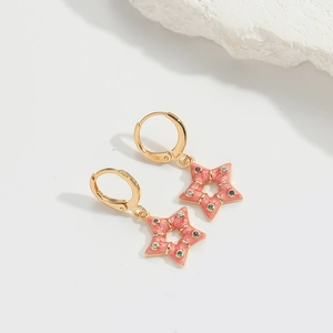 Close-up of pink star drop earrings with colorful rhinestones on a white marble stone