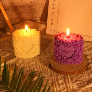 Close-up of heart-shaped rose candles with Love embossing in cream and purple colors