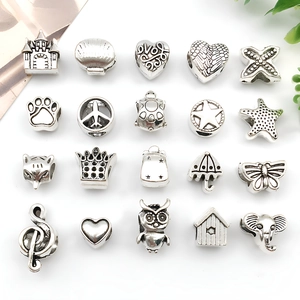 Flat lay of 20 silver alloy charms including castle shell and heart for DIY bracelets