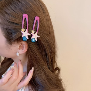 Detailed view of starfish hair clips in purple and pink on wavy brown hair