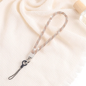 Detailed close-up of champagne luxury rhinestone chain lanyard with metal clasp on fabric