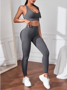 Dettaglio del tessuto a costine senza cuciture grigio scuro su reggiseno sportivo e leggings
