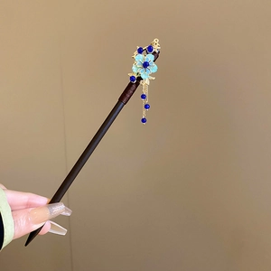 Detailed view of handmade flower hair stick with blue beads and elegant tassels
