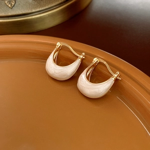 Detail shot of vintage crescent-shaped gold earrings with pearlescent white inlay in a tray