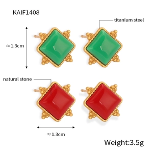 Detailed view of geometric titanium steel earrings with red and green natural stones
