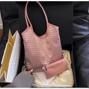 Detail der rosa Tragetasche mit Rauten-Nietenmuster und kleiner Tasche in Geschenkbox