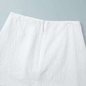 Close-up of white textured fabric with high-quality invisible zipper on a skirt