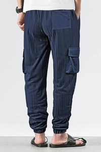 Rear view of men's dark blue plaid cargo pants featuring pocket details and jogger cuffs