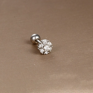 Macro detail of silver surgical steel cartilage stud featuring a sparkling zircon flower