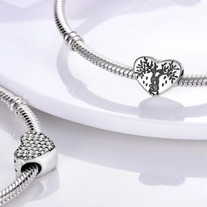 Detailed view of silver-plated snake chain bracelets with heart tree and crystal charms