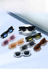Collection of retro thick square sunglasses in multiple colors on light blue background