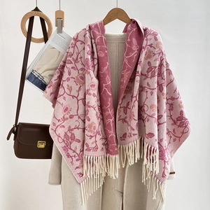 Close-up of pink jacquard floral pattern and soft fringe tassels on warm winter scarf