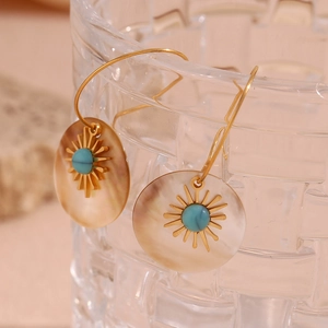 Macro detail of 18K gold-plated oval earrings with shell and turquoise sunburst design