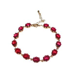 Elegant gold bracelet featuring oval-cut red zircon stones with an adjustable clasp design