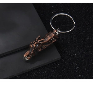 Detailed macro view of a vintage bronze motorcycle metal keychain on black base